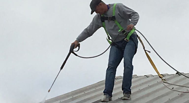 roofing pro spraying roof coating